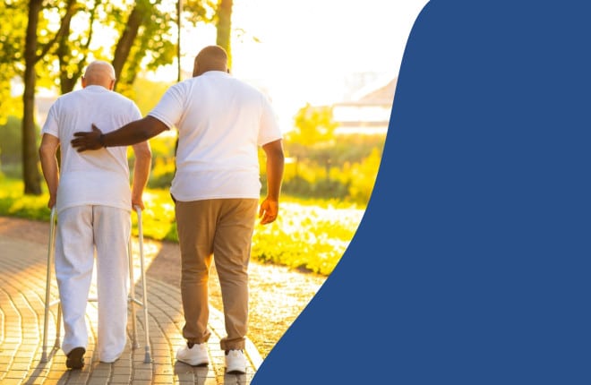 caregiver helping elderly man walk