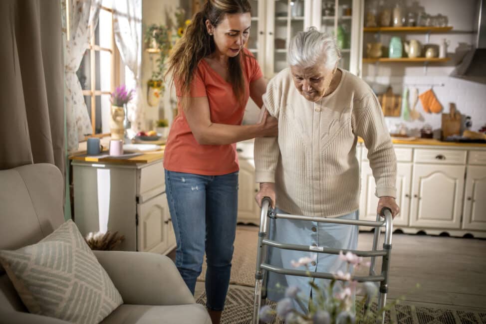 caregiver Assisting Senior Woman with Walker at home